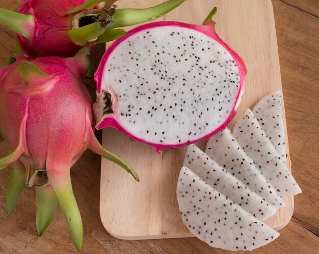 Dragon fruits on wooden background, Sliced delicious dragon fruit on wooden background.