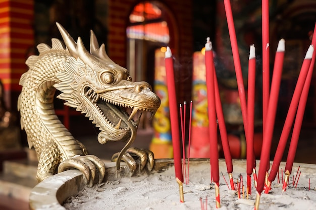 A dragon statue next to candles in a temple