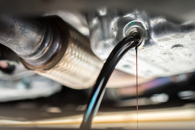 Drain the old oil from the engine through the drain plug. Changing the oil in a car engine.