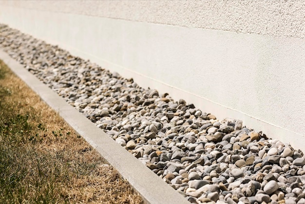 Ghiaia di drenaggio, sassi di drenaggio, ghiaia intorno al muro della casa. pavimento di scarico per acqua piovana