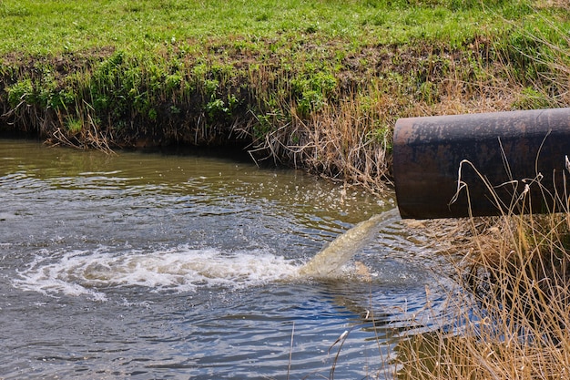 Photo draining sewage from pipe into river pollution rivers and ecology