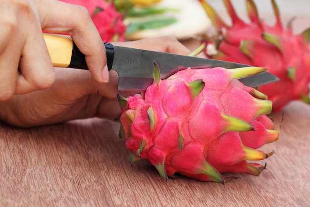 Drakenfruit snijden met mes op houten oppervlak