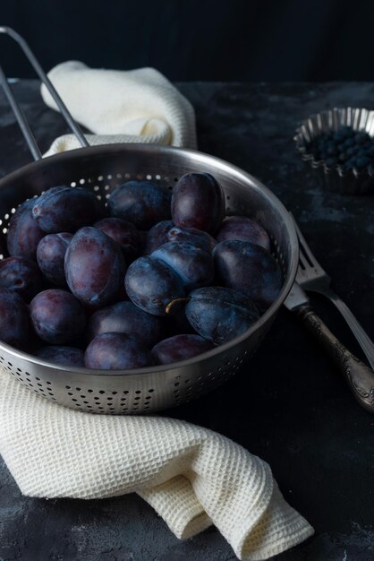 Dramatic autumn still life with plums on a dark background Rustic