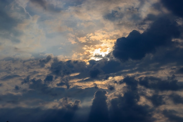 Dramatic blue sky with dark clouds and orange sun