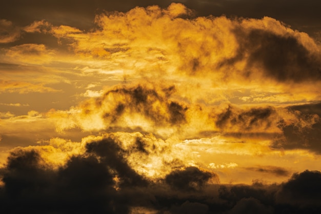 Dramatic clouds illuminated rising of sun in sky to weather change. Natural weather conditions background. Soft focus, motion blur. Cloudscape image ready for design, replace sky in photo editor.