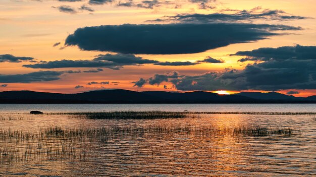 Dramatic cloudy sunset scenery mountains in background at corrib lake in galway ireland