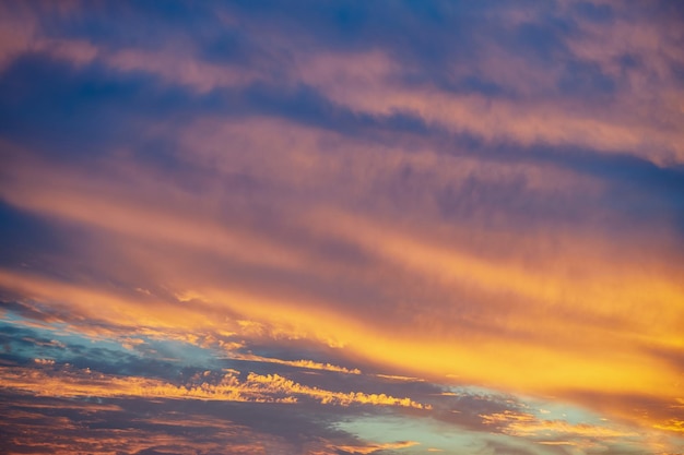 Dramatic colorful sunset Fantasy landscape with clouds and orange sunset Lines of clouds lighted by orange sundown sun