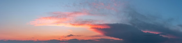 Dramatic gloomy panorama of bright saturated sunset with large dark clouds