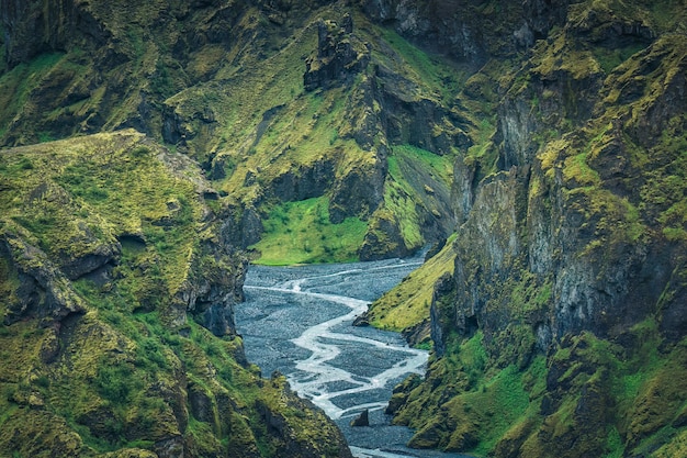 Dramatic landscape of lush rugged volcanic mountain valley with river flowing in summer on Icelandic highlands at Thorsmork Iceland