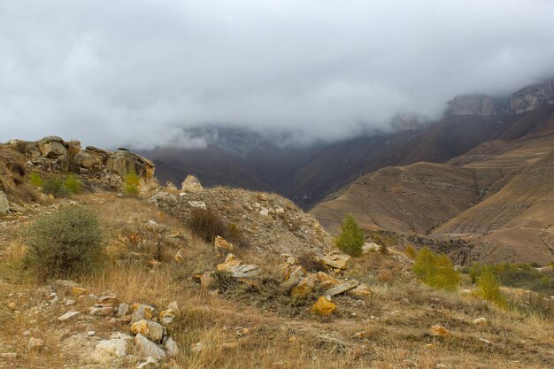 Dramatic landscape steep cliffs and green hills with cloudy sky and fog in the Elbrus region North Caucasus Russia and soft blurred focus