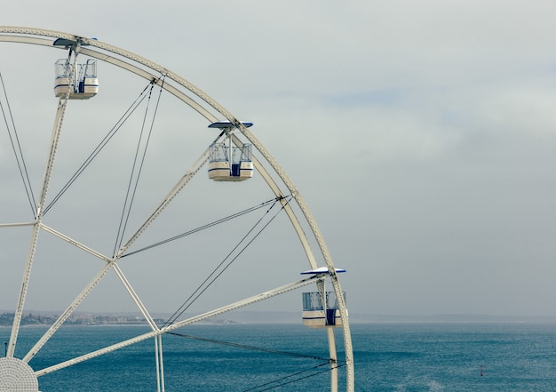 Foto drammatico colpo lunatico della ruota panoramica a cascais, portogallo contro il cielo nebbioso