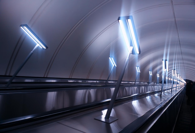 Dramatic moving staircase at city metro with dramatic illumination background