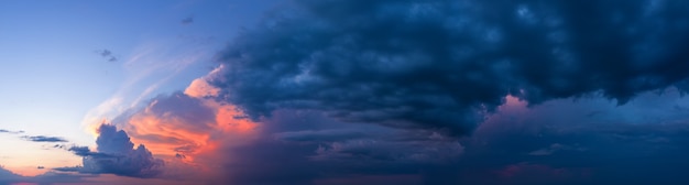 暗い嵐の雲と夕焼け空の劇的なパノラマ。