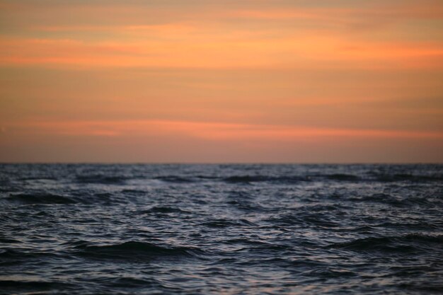 夕暮れの劇的な赤い海の波と 柔らかい夕方の海の暗い水