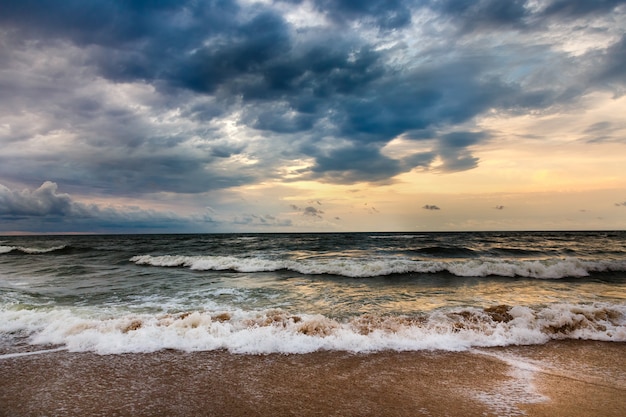 朝の海景に劇的な空。砂浜のビーチで嵐。