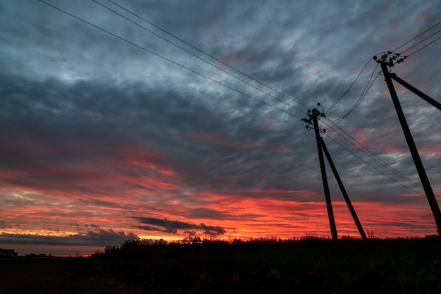 Драматическое небо powerline в закат облака сцены отражение после дождя