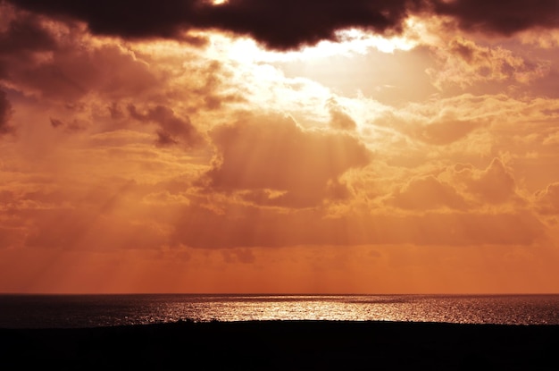 Photo dramatic sky over sea during sunset