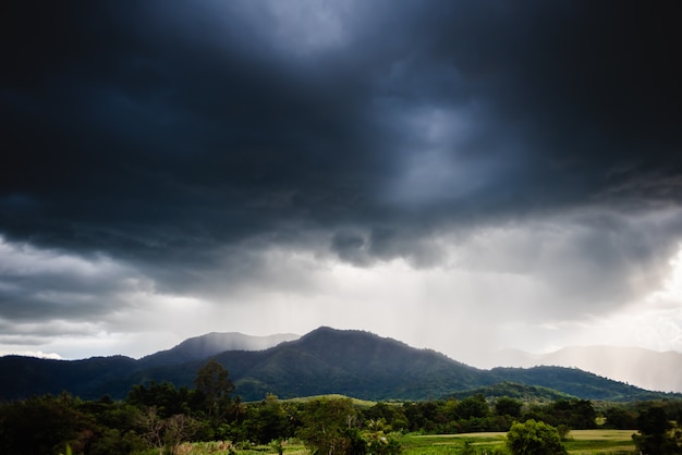 Dramatic storm clouds with rain on mountain