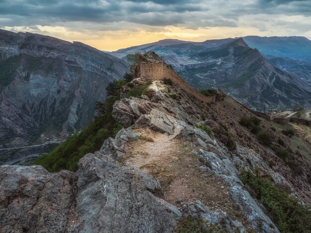 Dramatic sunrise at the ancient fortress on the top of the mountain. The Gunib fortress is a historical monument of Dagestan. Russia.