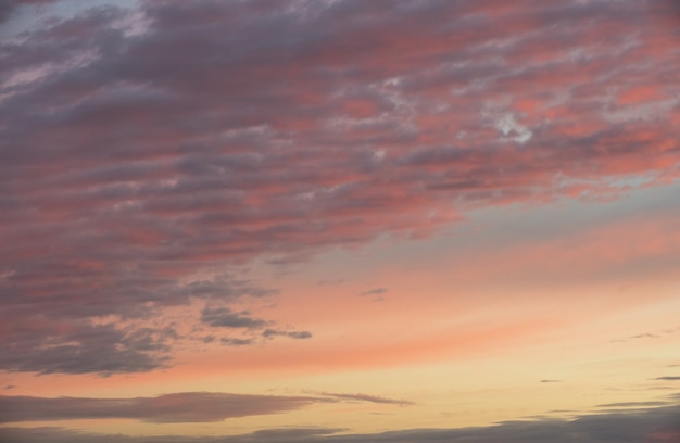 Dramatic sunset pink orange red sky with clouds, bright soft sunrise horizontal scenery texture