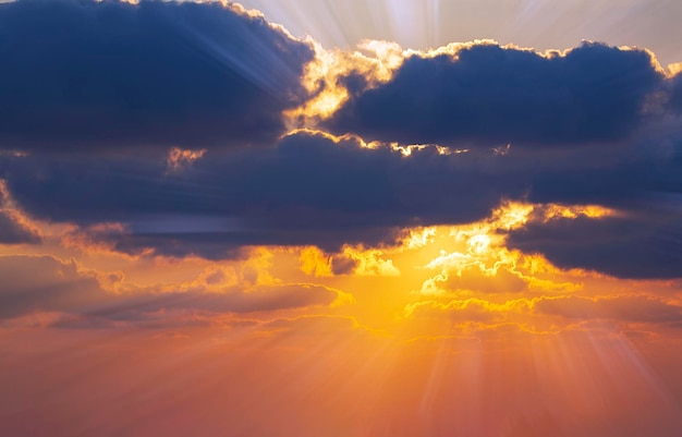 Dramatic yellow sunset sky wallpaper Beautiful dark blue sky evening beauty and cloud at sunset dawn the rays of the sun break through the clouds Dusk colorful horizon background Travel concept