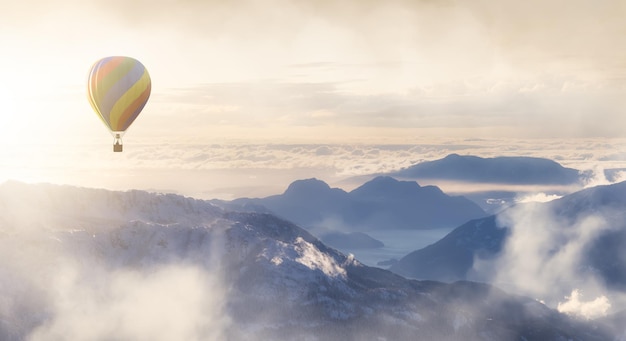 Dramatisch berglandschap bedekt met wolken en heteluchtballonvliegen