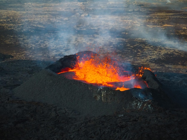 Dramatisch uitzicht op een uitbarsting van een vulkaan met rood magma dat in een krater kookte en extreme hoge temperaturen veroorzaakte