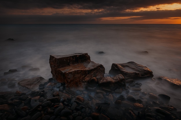 Dramatisch zonsonderganglandschap met lange blootstelling met de rotsachtige kust van de Zwarte Zee