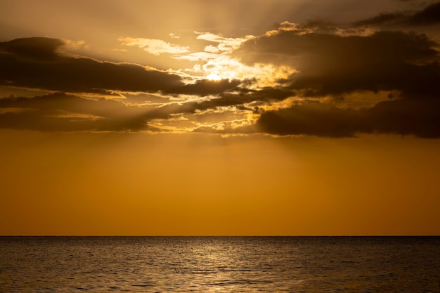 Dramatische rode oceaangolven bij zonsondergang met zacht avondzee donker water