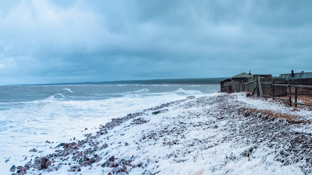 Dramatische stormachtige dag op het strand. breed panorama. kashkarantsy visserij collectieve boerderij. een klein authentiek dorpje aan de witte zeekust. kola-schiereiland. rusland.