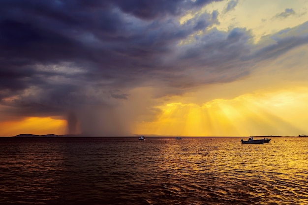 Dramatische zonsondergang en aanstaande regenbui op zee