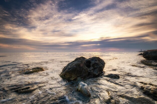 Dramatische zonsondergang over het strand met een natuurlijke vijver op de voorgrond