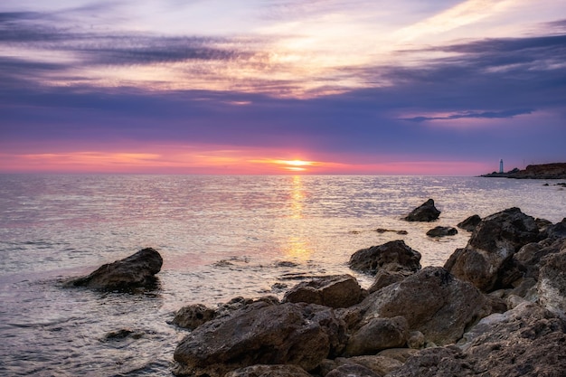 Dramatische zonsondergang over het strand met een natuurlijke vijver op de voorgrond