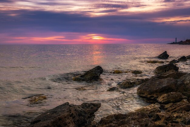 Dramatische zonsondergang over het strand met een natuurlijke vijver op de voorgrond