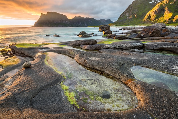 Dramatische zonsondergang over het strand van Uttakleiv op de Lofoten-eilanden Noorwegen