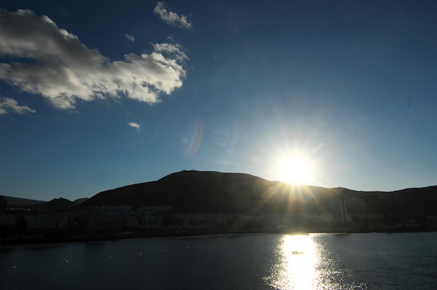 Dramatische zonsondergangstralen achter het silhouet van een berg