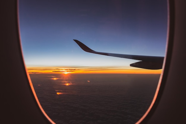 Foto dramatische zonsopgang boven wolken uitzicht vanuit vliegtuigraam vluchtconcept geweldige ochtend boven wolken