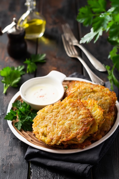 Draniki served with fresh herbs and garlic yogurt sauce