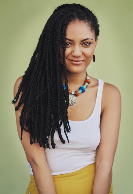 Photo draped in gorgeous dreads portrait of an attractive young woman posing against a green background