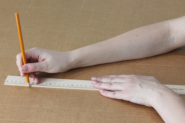 Draw with a pencil along the ruler on cardboard, cut out the\
base for the product with your own hand