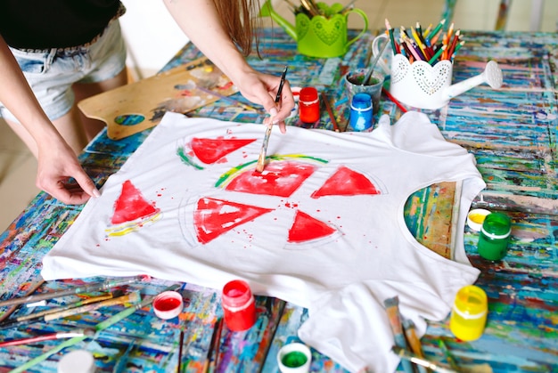 Photo drawing on clothes. girl draws on a white t-shirt.