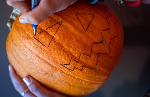 Drawing a face on a pumpkin for Halloween
