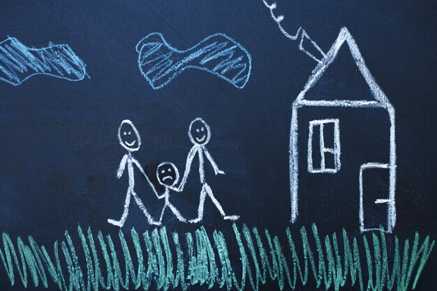 Drawing happy homosexual parents with unhappy child in the family on a chalk board