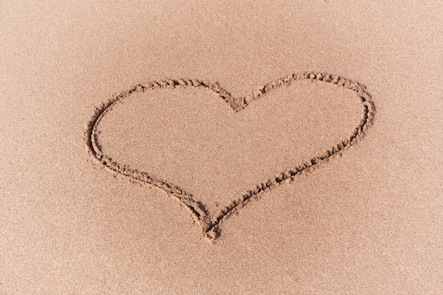 Drawing of a Heart on a Yellow Sand Beach extreme closeup.