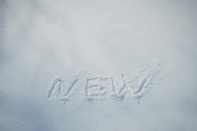 Drawing in the snow, words written by a human hand. New Year's concept.