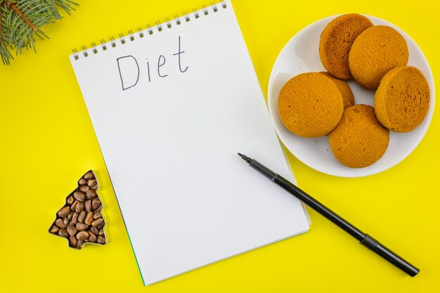 Drawing up a diet for the coming year against the background of New Year's cookies.