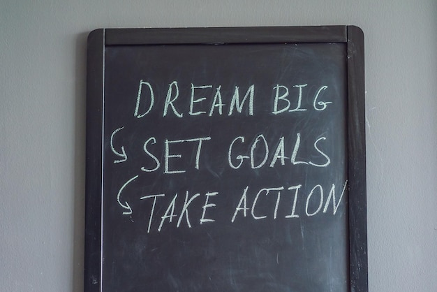 Foto dream big set goal take action scrittura a mano su una lavagna