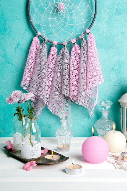 Dream catcher on aquamarine wall background