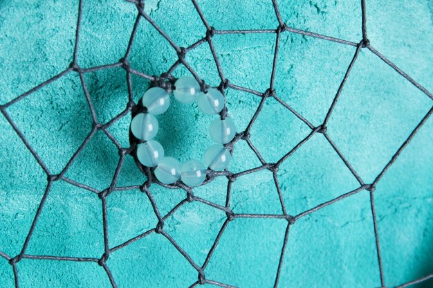 Dream catcher on aquamarine wall 