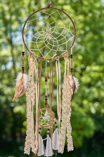 Dream catcher and green trees on the background